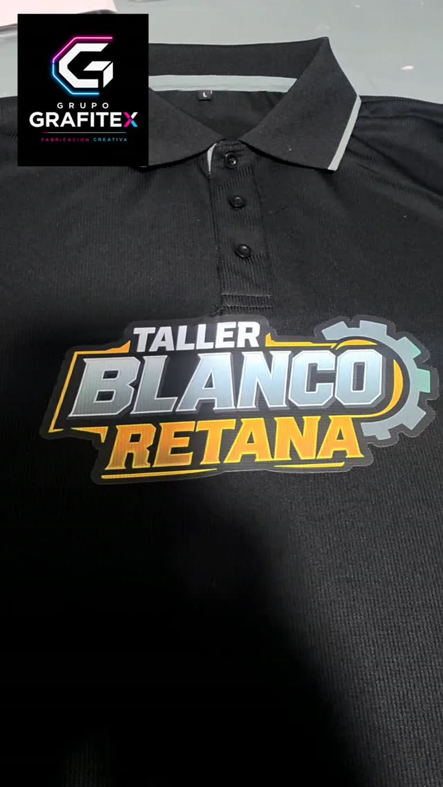 Camisa tipo polo negra con el logo de Taller Blanco Retana estampado en DTF