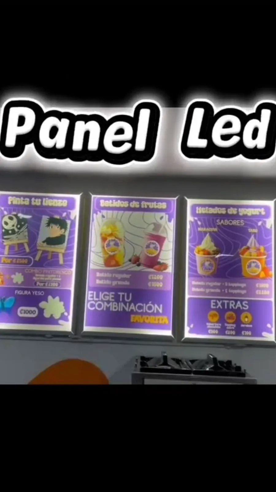 Tres paneles LED iluminados con el menú de batidos y helados de una heladería